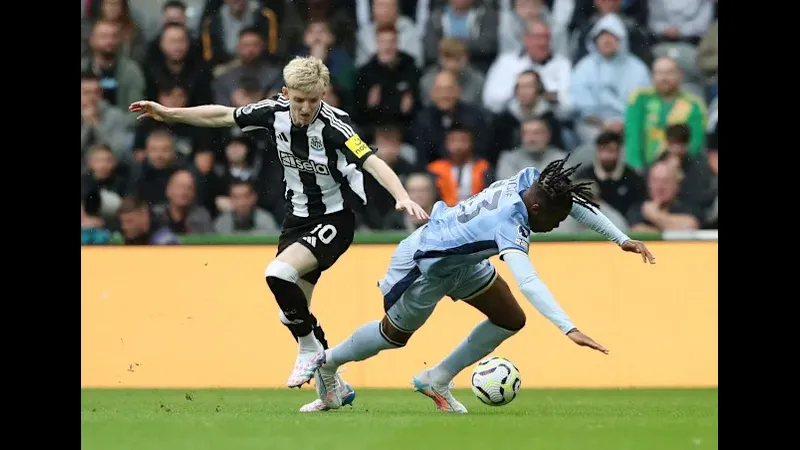 Cầu thủ Newcastle dùng kỹ thuật đi bóng qua cầu thủ Tottenham trên sân cỏ Cầu thủ Newcastle dùng kỹ thuật đi bóng qua cầu thủ Tottenham trên sân cỏ