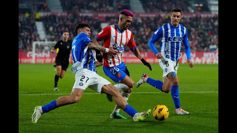 Cầu thủ Alaves và Girona tranh chấp quả bóng trên sân cỏ Cầu thủ Alaves và Girona tranh chấp quả bóng trên sân cỏ